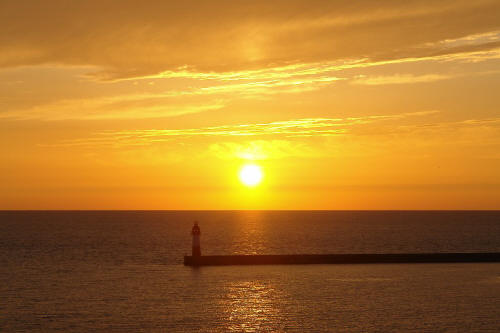 фотография 131 маяк на море пирс волнорез причал солнце закат желтое небо мелкая рябь на воде